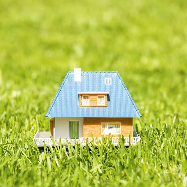 Small plastic house on green grass — Stok fotoğraf