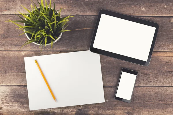 Espaço de trabalho com tablet digital, telefone e papel branco em t de madeira — Fotografia de Stock