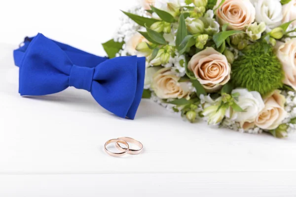 Wedding rings and accessories on white wooden table — Stock Photo, Image