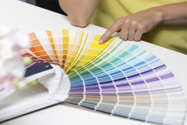 Женщина выбирает цвет краски из образцов тона — стоковое фото