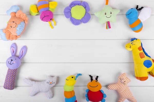 Jouets de bébé doux colorés sur fond en bois avec espace de copie — Photo