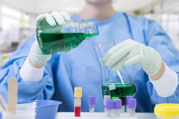 Forskare fylla en kolv i ett kemiskt laboratorium — Stockfoto