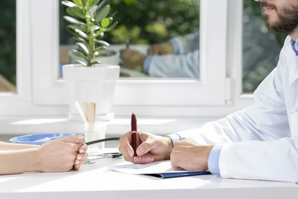 Läkare och patient sittande vid bordet — Stockfoto