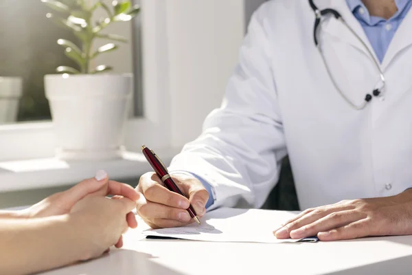 Ärztliche Beratung - Arzt und Patient sitzen am Tisch — Stockfoto