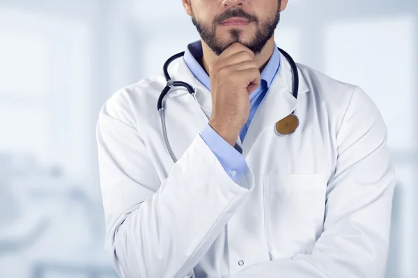 Läkare står med handen på hakan — Stockfoto
