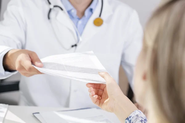 Arzt gibt Patient ein Dokument — Stockfoto