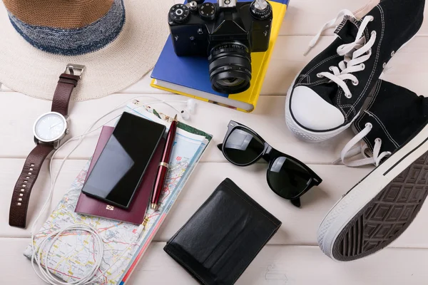 Viajantes itens de férias na mesa de madeira branca — Fotografia de Stock