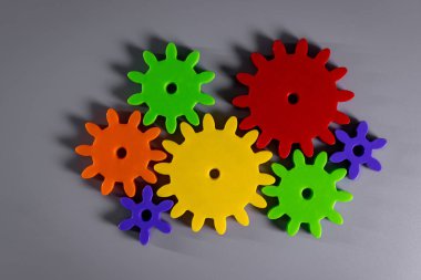 Gri arka planda renkli bağlı vitesler. en üstteki görünüm