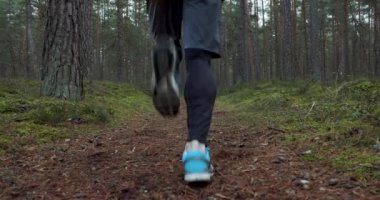 Açık hava antrenmanı. Orman yolunda koşan adam. Yavaş çekim kaydırma görüntüsü