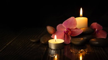 Orkide çiçeği, spa taşları ve mumlarla. Meditasyon ve uyum kavramı