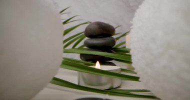 Spa ve sağlık - masaj taşlarının üzerinden beyaz havluların arasından kayıyor