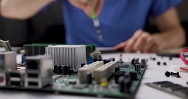 Elektronik tamir ve bakım servisi. Ofiste bilgisayar parçalarıyla çalışan bir teknisyen. kaydırıcı atışı
