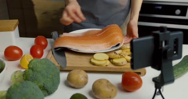 食物博客在家里厨房用电话摄像头记录视频 展示鲑鱼烹调食谱 — 图库视频影像
