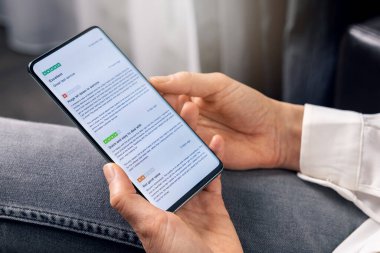 İnternet üzerinden alışveriş öncesi hizmet ve ürün kalitesi hakkında müşteri değerlendirmelerini okumak için telefonu kullanan kadın