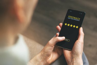 Müşteri geribildirimi - kadın iyi hizmet için 5 yıldız puanı vermek için telefonu kullanıyor