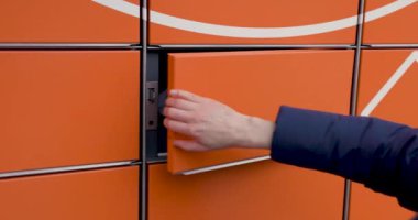 self servis terminal makinesinden paket al. Dolabı aç ve paketi çıkar.