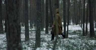 Kahverengi kapüşonlu seri katil kışın ormanda baltayla dolaşıyor.