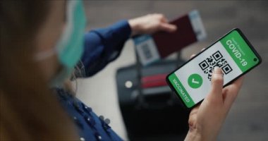Aşılanmış kişi cep telefonunda dijital sağlık pasaport uygulaması ve havaalanında güvenli seyahat için covid 19 aşı sertifikası kullanıyor.