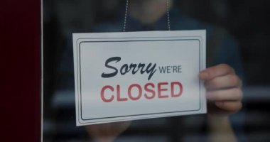 Dükkan sahibi cam kapıdaki tabelayı açtı.