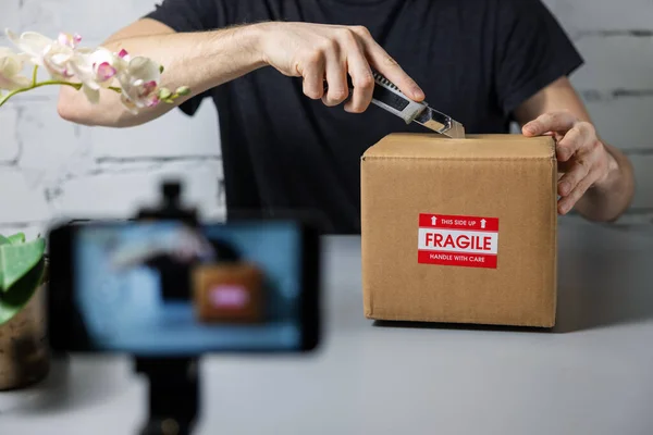 Человек Запись Unboxing Видео Мобильного Телефона Резание Картонной Коробки Ножом — стоковое фото