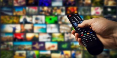 Arka planda televizyon kanalları ve elinde uzaktan kumanda. akıllı televizyon ve talep konsepti içeriği