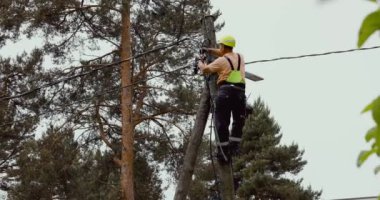 Elektrik kablosunu elektrik direğine bağlayan adam. elektrik hattı bakım ve onarımı