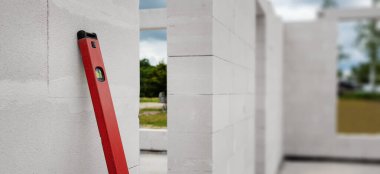 Otoklavlı beton blokları olan inşaat halindeki bir ev. Pankart