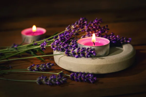 lavender with scented candles on wooden background