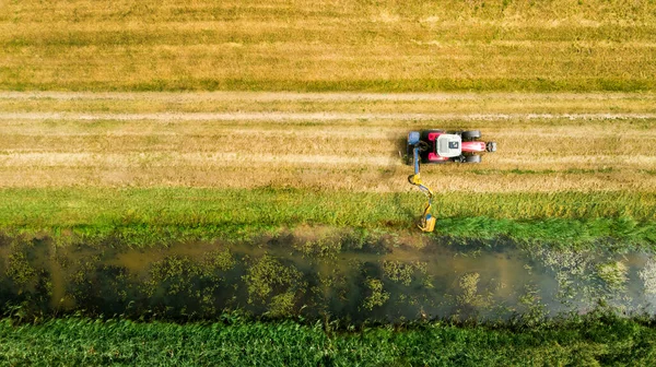 drainage ditch cleaning with tractor. aerial view