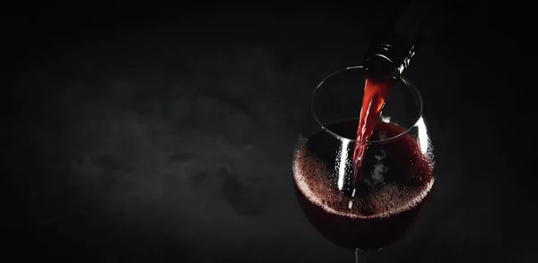 Κόκκινο Κρασί Ρίχνει Ένα Ποτήρι Από Μπουκάλι Μαύρο Φόντο Κενό — Φωτογραφία Αρχείου