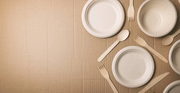 环保即弃餐具 硬纸板背景上的纸盘和木制餐具 复制空间 — 图库照片