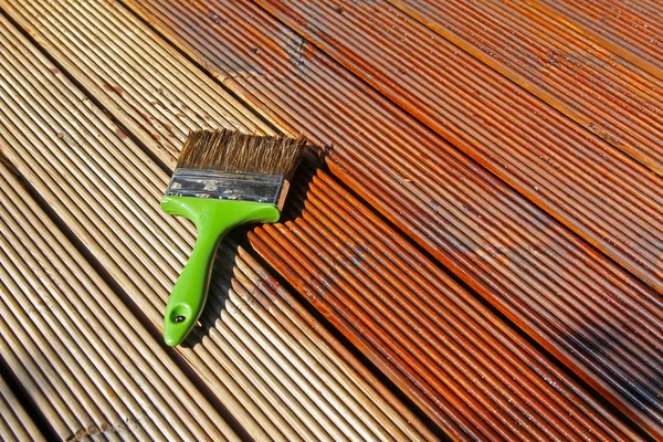 Painting wooden patio deck with protective oil — Stock Photo, Image