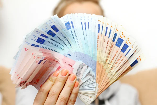 Mujer sostiene billetes en euros en frente — Foto de Stock