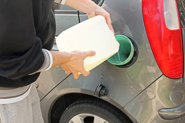 Verser de l'essence dans le réservoir d'essence à partir d'une cartouche blanche — Photo