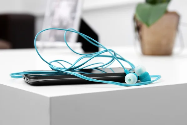 Smart phone with earphones on the table — Stock Photo, Image