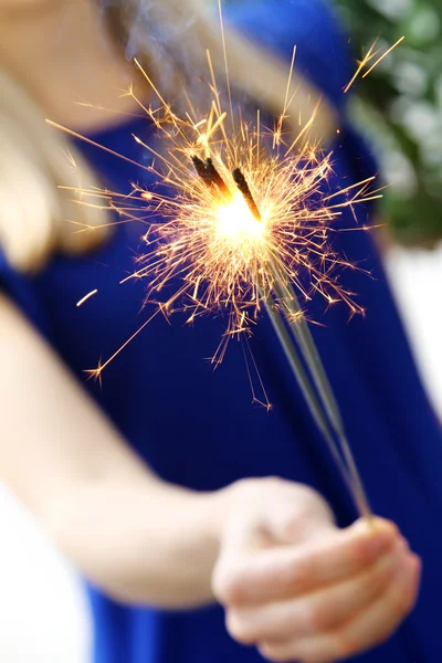 Mulher segurando sparklers em sua mão — Fotografia de Stock