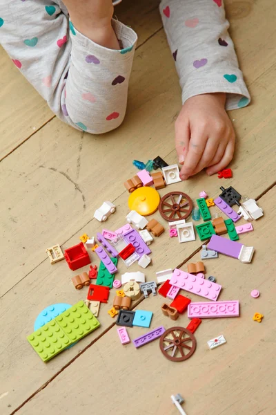 Enfant joue avec les blocs de construction sur le sol — Photo