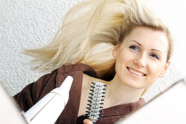 Jovem feliz golpe secagem cabelo no banheiro — Fotografia de Stock