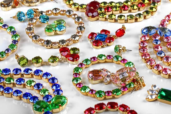 Variety of gemstone jewelry on white table — Stock Photo, Image