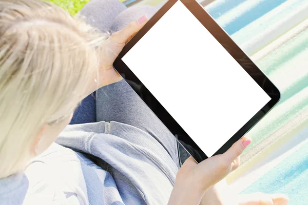 Over the shoulder view of a woman relaxing in a hammock using a — Stock Photo, Image