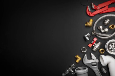 Siyah arkaplanda fotokopi alanı olan tesisat araçları ve montajlar. Tesisat ekipmanı