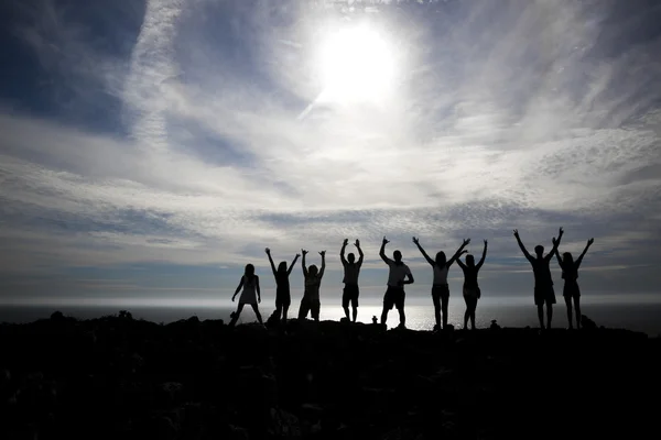 Happy people silhouettes on the beach — Stock Photo, Image