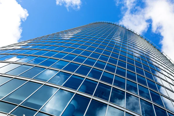 Företag bygga fönster mur mot blå himmel — Stockfoto