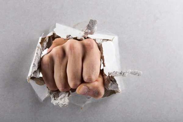 Concetto di aggressione, muro è rotto da un pugno — Foto Stock