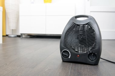 Oda Laminat zemin üzerinde siyah elektrikli ısıtıcı
