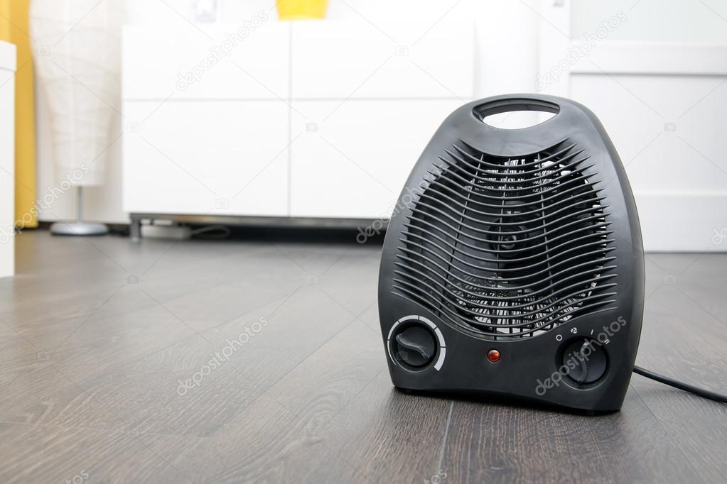 black electric heater on laminate floor in the room