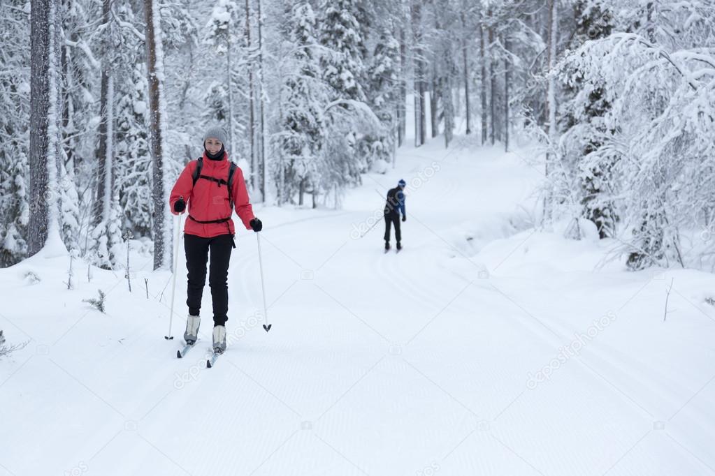 woman cross-country skiing in the snowy forest