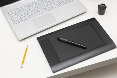 Dijital çizim tablet ve masanın üstünde laptop