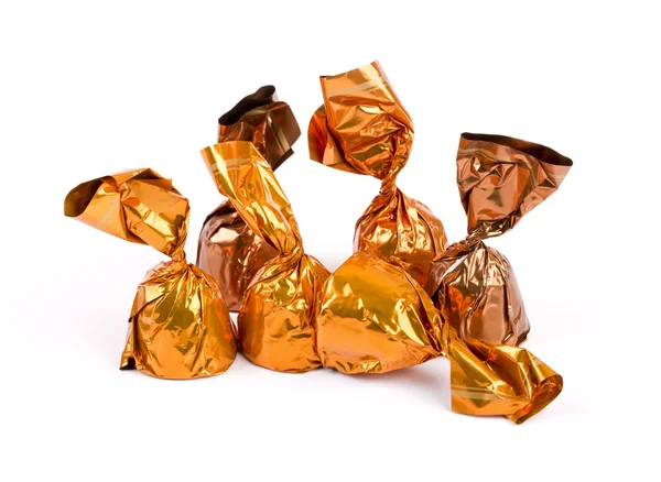 Groep van chocolade snoepjes verpakt in glanzend papier op wit — Stockfoto