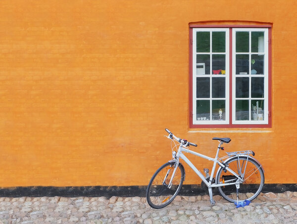 Bike on the background of the city wall with a window
